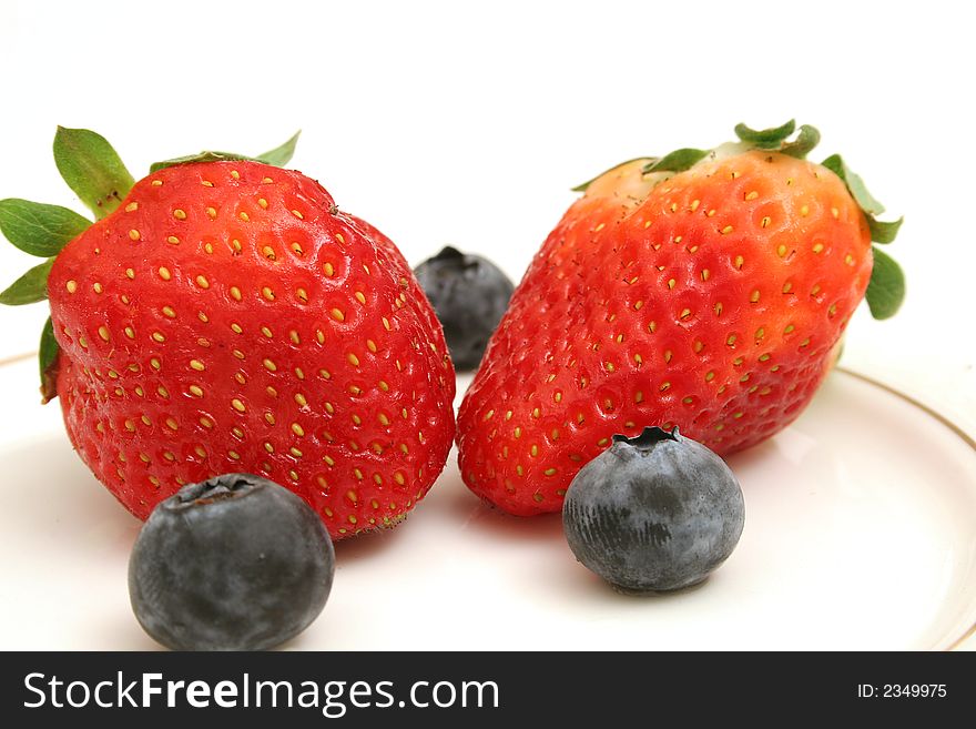 Picture of Two strawberries & blueberries upclose