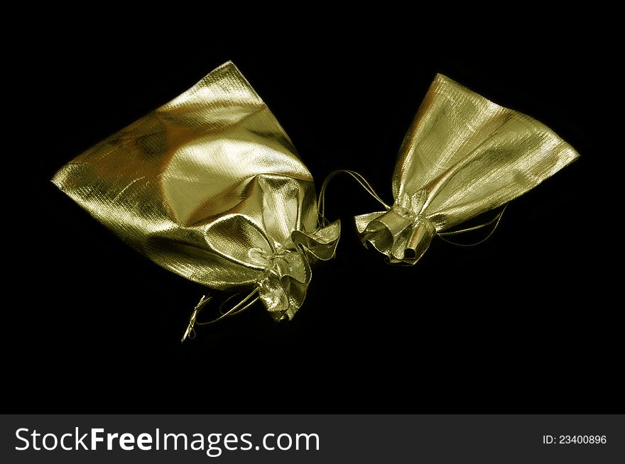 Two soft golden bags of different size over black