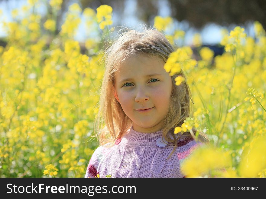 Portrait of a girl on a background of yellow flowers summer. Portrait of a girl on a background of yellow flowers summer