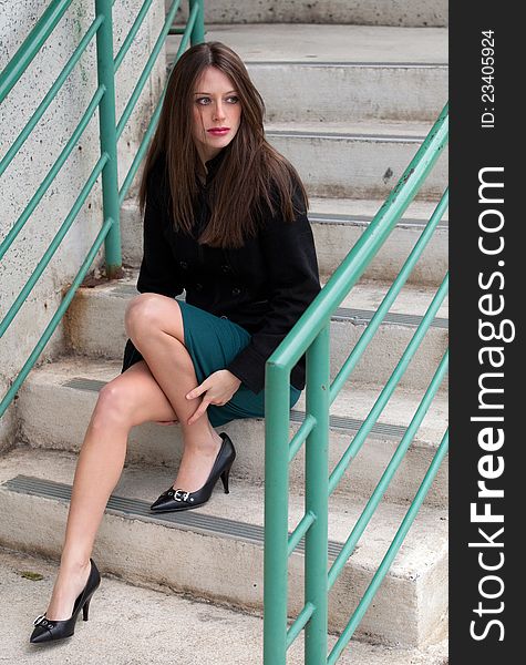 A portrait of a gorgeous, elegant woman in a jacket, skirt, and heels on an urban stairway. A portrait of a gorgeous, elegant woman in a jacket, skirt, and heels on an urban stairway