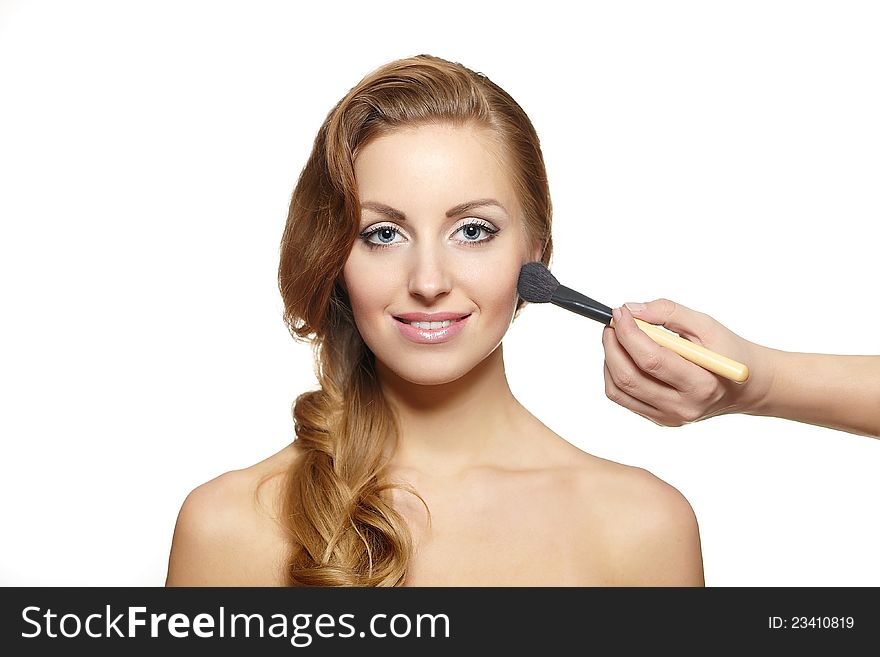 Makeup artist applying  makeup to attractive girl