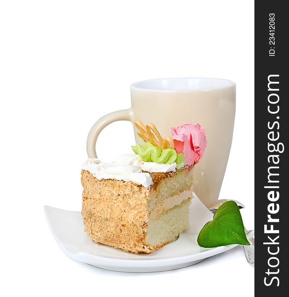 Piece of cake with cream, green sheet, cup and tea-spoon on a white background. Piece of cake with cream, green sheet, cup and tea-spoon on a white background