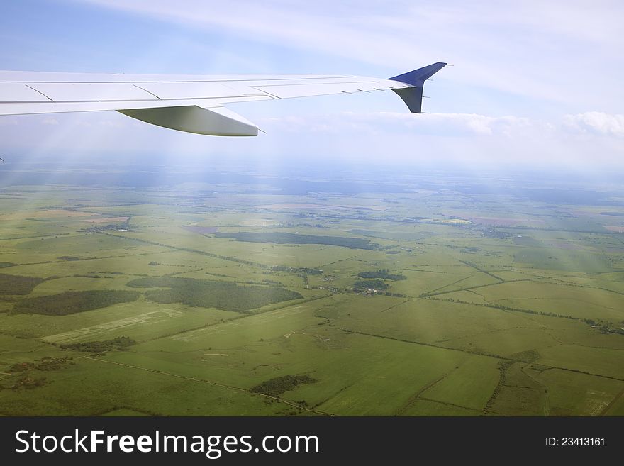 Wing of an airplane and the land below. Wing of an airplane and the land below