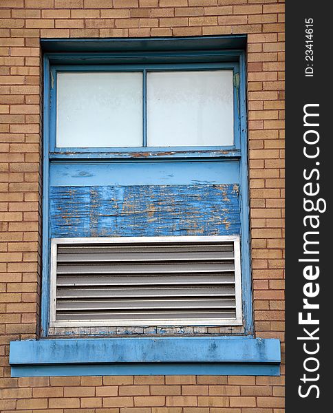 Old blue window in brick wall