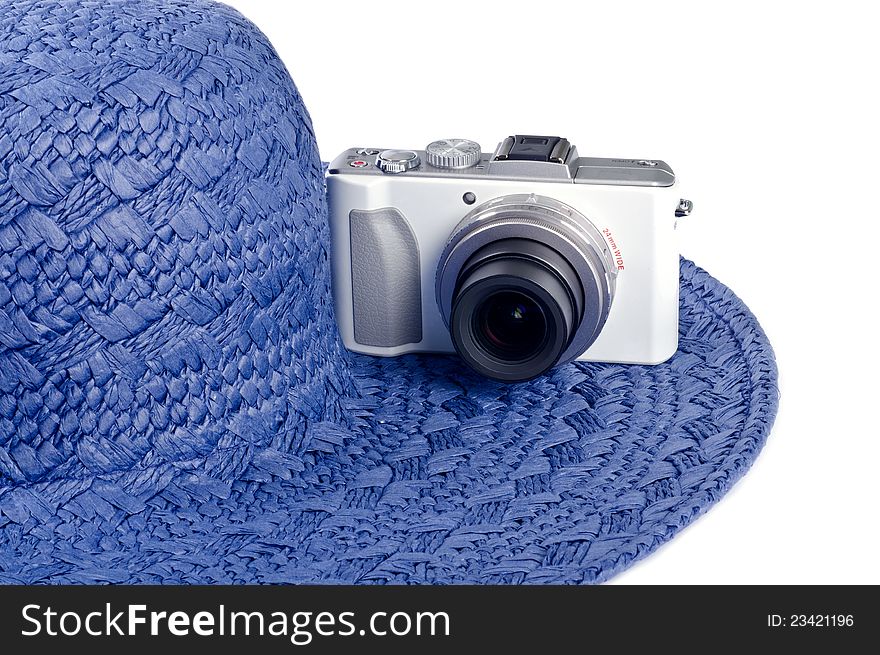 A blue straw hat and a white digital camera. A blue straw hat and a white digital camera.