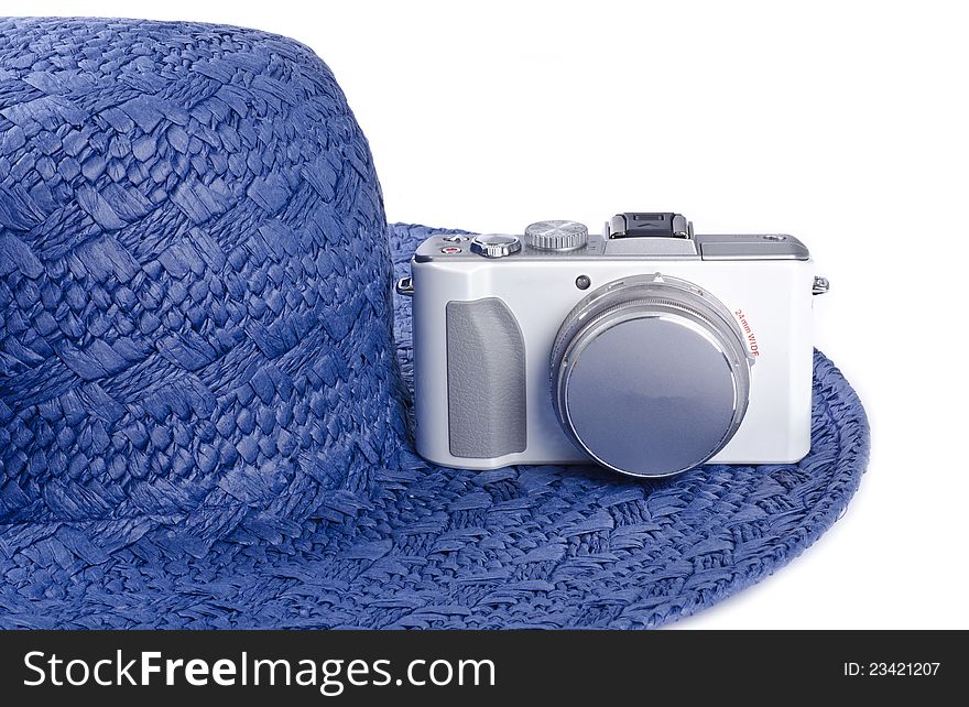 A blue straw hat and a white digital camera. A blue straw hat and a white digital camera.
