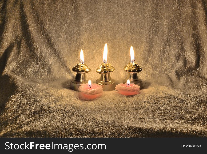 Five candles an a beige fabric material shining in harmony, mushrooms like an flower candles. Five candles an a beige fabric material shining in harmony, mushrooms like an flower candles
