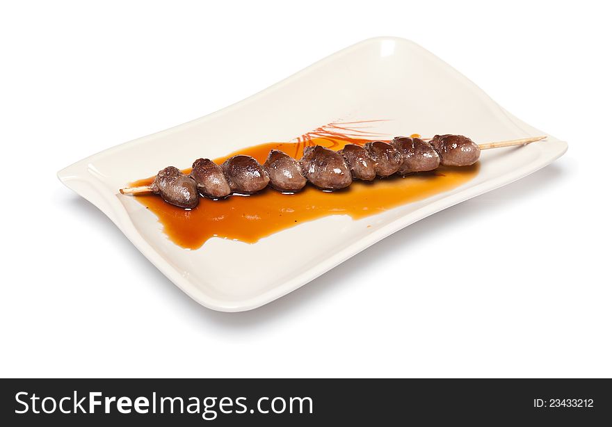 Grilled Chicken Heart on a skewer with sauce on a white plate on white background