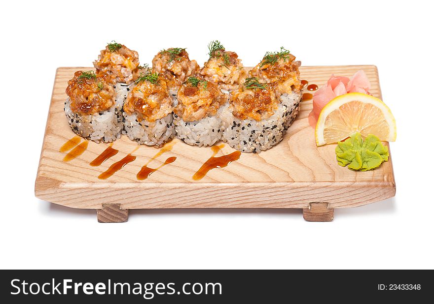 Maki Sushi - Roll on a wooden plate on white background with wasabi, lemon and ginger