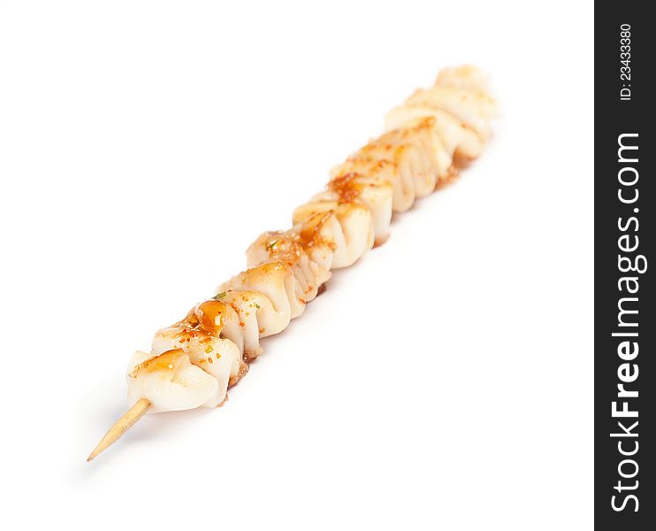 Skewered squid on wooden sticks grilled on white background