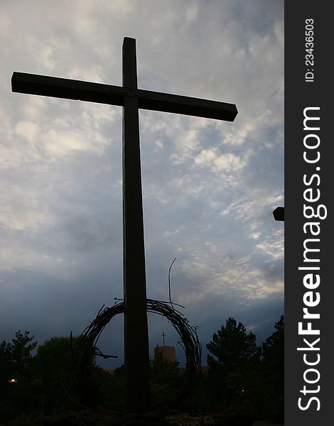 Crucifix, wreath at base framing mission steeple. Crucifix, wreath at base framing mission steeple