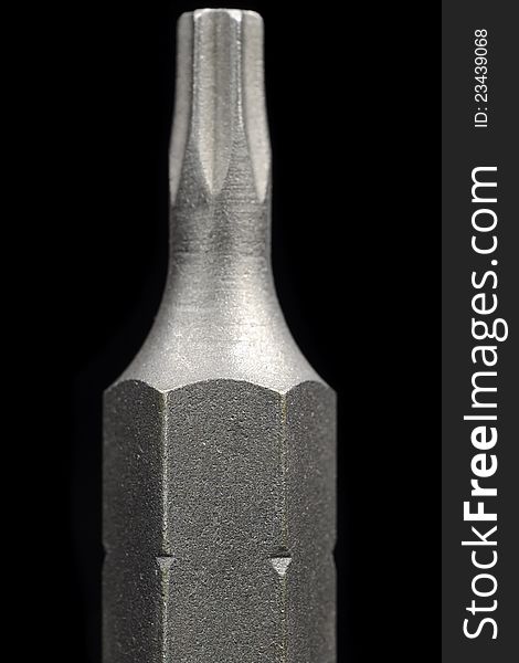 A close-up shot of a torx screwdriver bit on a black background. A close-up shot of a torx screwdriver bit on a black background