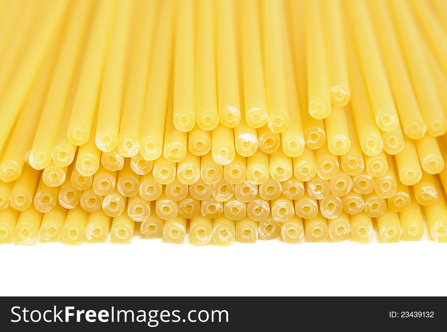 A close-up shot of raw perciatelli pasta on a white background. A close-up shot of raw perciatelli pasta on a white background