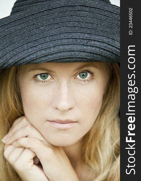 Portrait of a green-eyed girl in a hat