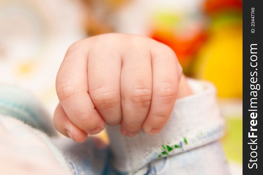 Baby's fist. Baby's hand on soft background. Baby's fist. Baby's hand on soft background