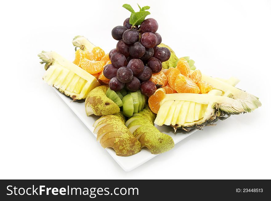 Plate of sliced fruit in a nice restaurant on a white background