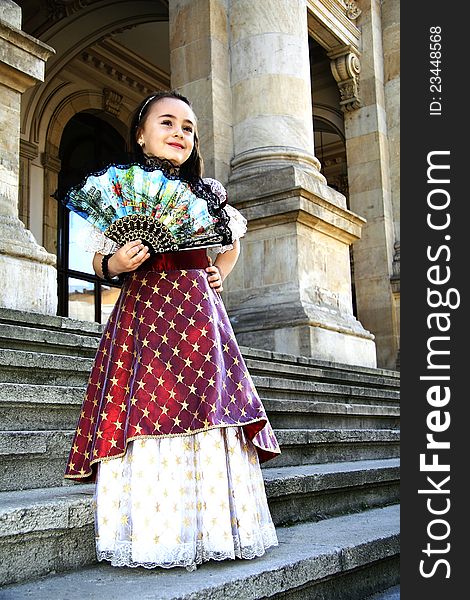 Girl dressed in vintage dress with fan in hand. Girl dressed in vintage dress with fan in hand