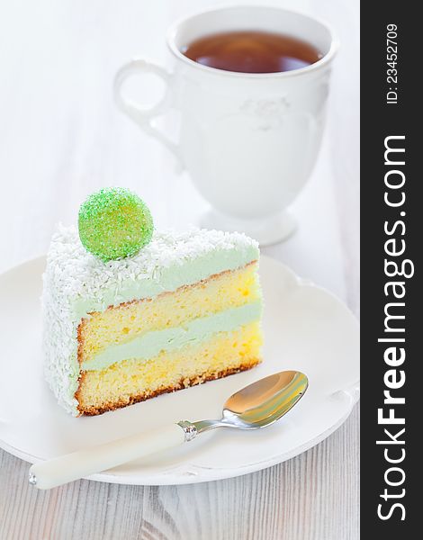 Saffron sponge cake with cream green tea, slice on a plate, selective focus. Saffron sponge cake with cream green tea, slice on a plate, selective focus