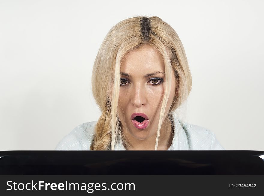 Beautiful girl sitting at a laptop and he was surprised at the background. Beautiful girl sitting at a laptop and he was surprised at the background