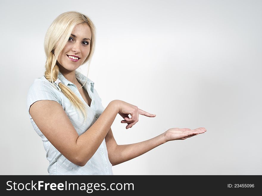 Happy beautiful girl indicates hand on the background of