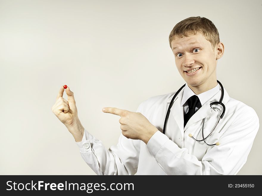 The guy doctor indicates the pill on the background of. The guy doctor indicates the pill on the background of