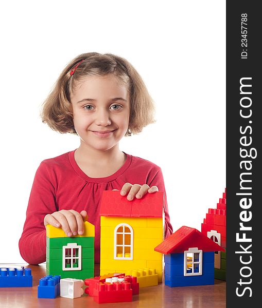 Cute little girl is constructing a house using building blocks