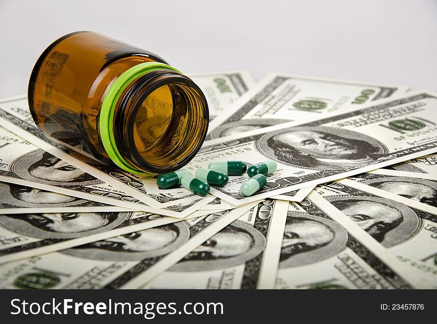 Some medicine and its bottle on dollars. Some medicine and its bottle on dollars