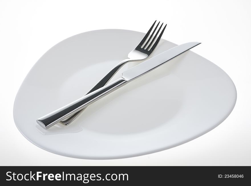 Fork and knife on a plate over white