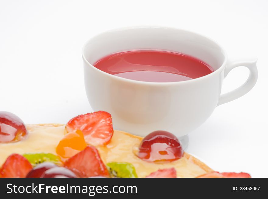Fruit cake and tea over white background