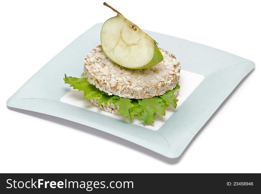 Gramineae Crispbread with Salad leaves and apple isolated on blue plate