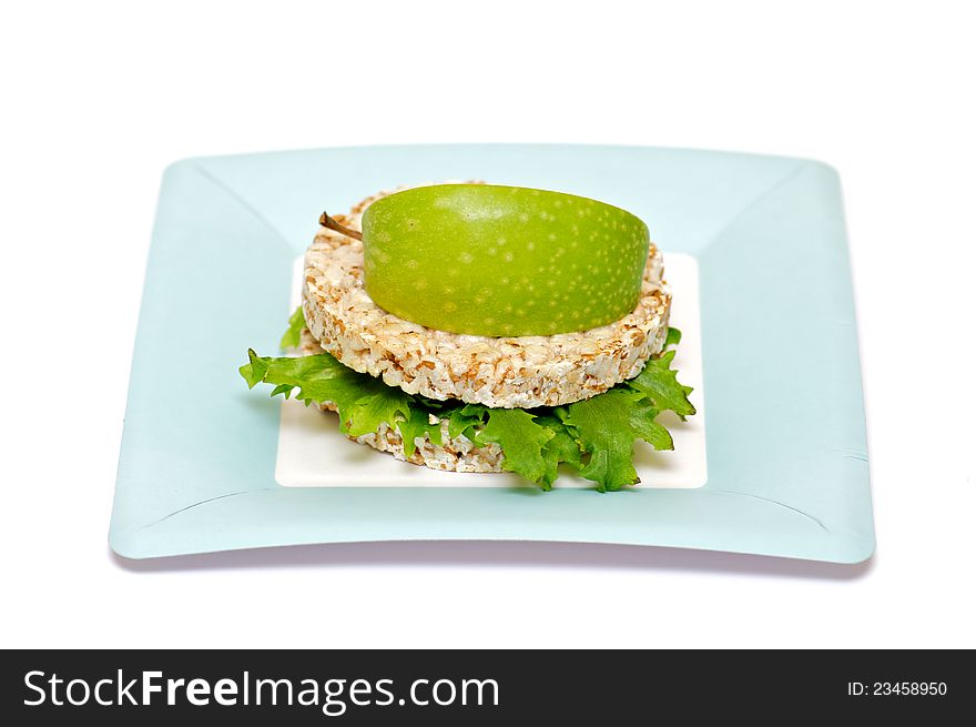 Gramineae Crispbread with Salad leaves and apple isolated on blue plate