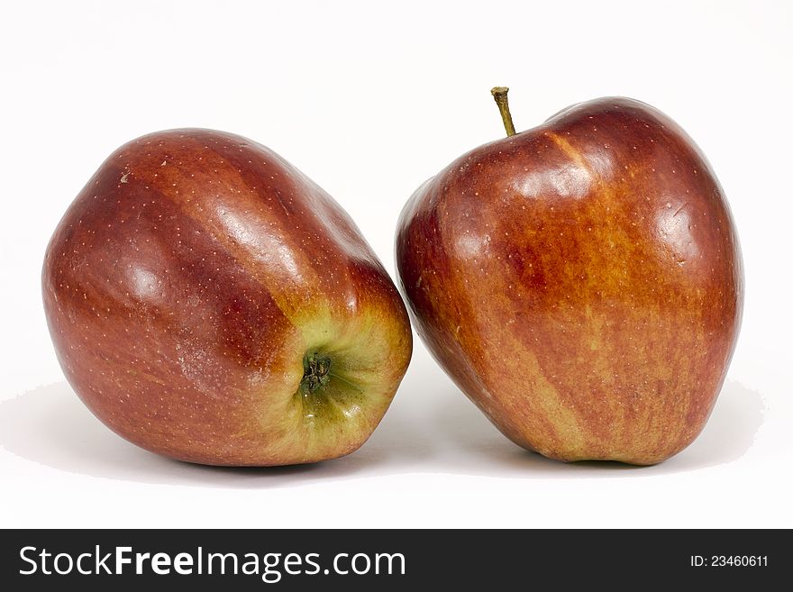 Two ripe red apples in the foreground. Isolated on a white background