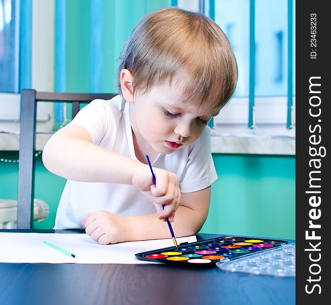 Cute little boy painting with watercolors