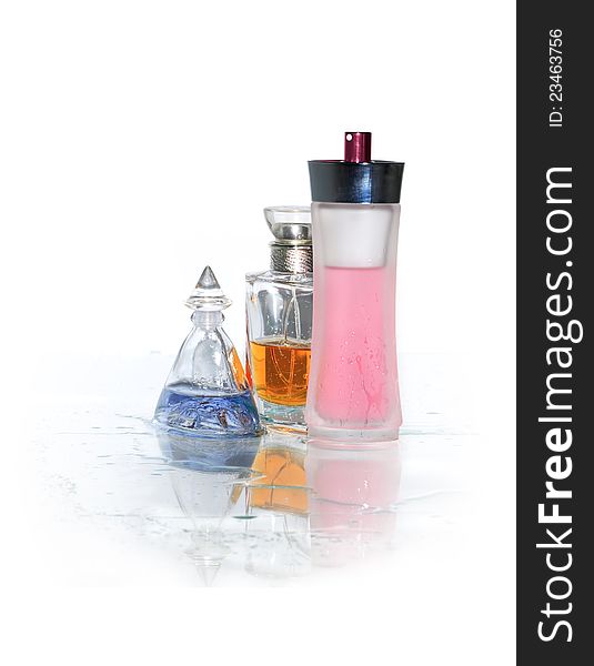 Three bottles of perfume standing on wet glass surface. Clipping path is included. Three bottles of perfume standing on wet glass surface. Clipping path is included