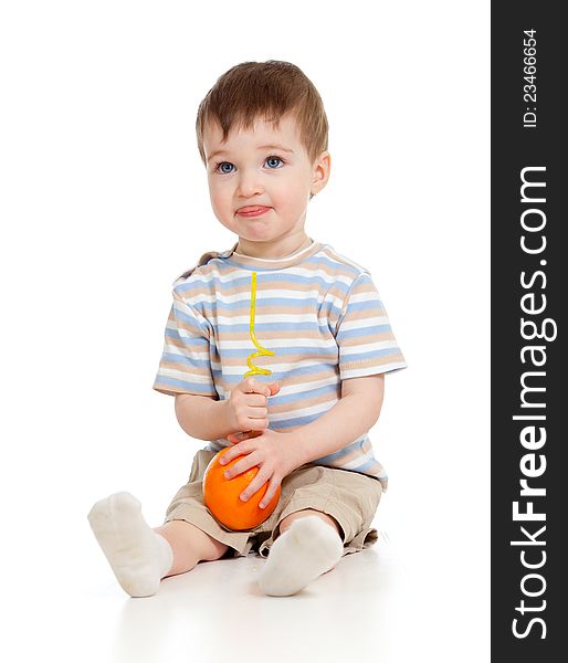 Funny child drinking orange through straw over white background. Funny child drinking orange through straw over white background