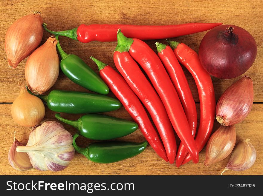 Red and green hot chili peppers on old wooden table. Red and green hot chili peppers on old wooden table.