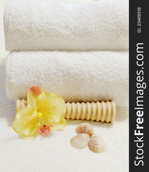 Foot massager with white folded towels, yellow orchid and seashells. Foot massager with white folded towels, yellow orchid and seashells