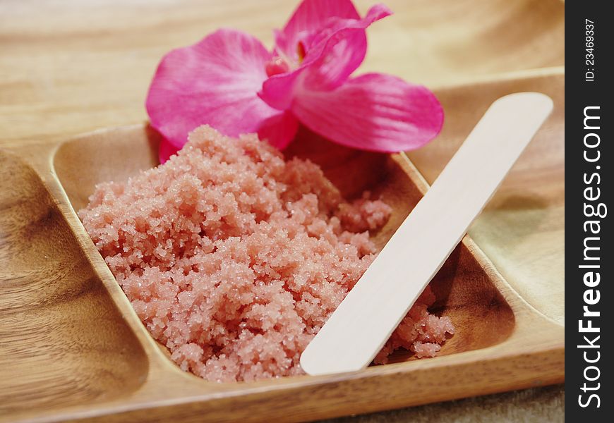 Spa Crystals in wood container with spatula and pink orchid