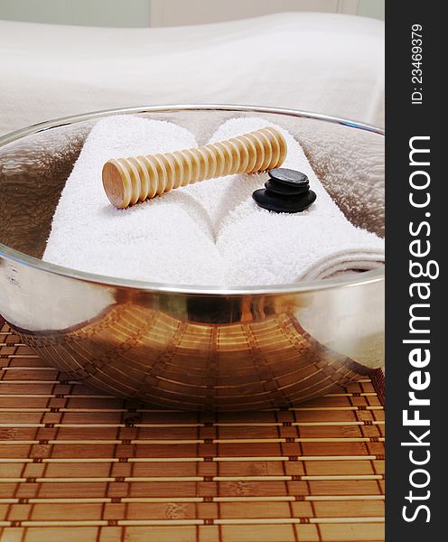 Foot Massager with Towels in Bowl on Bamboo Mat with yellow orchid