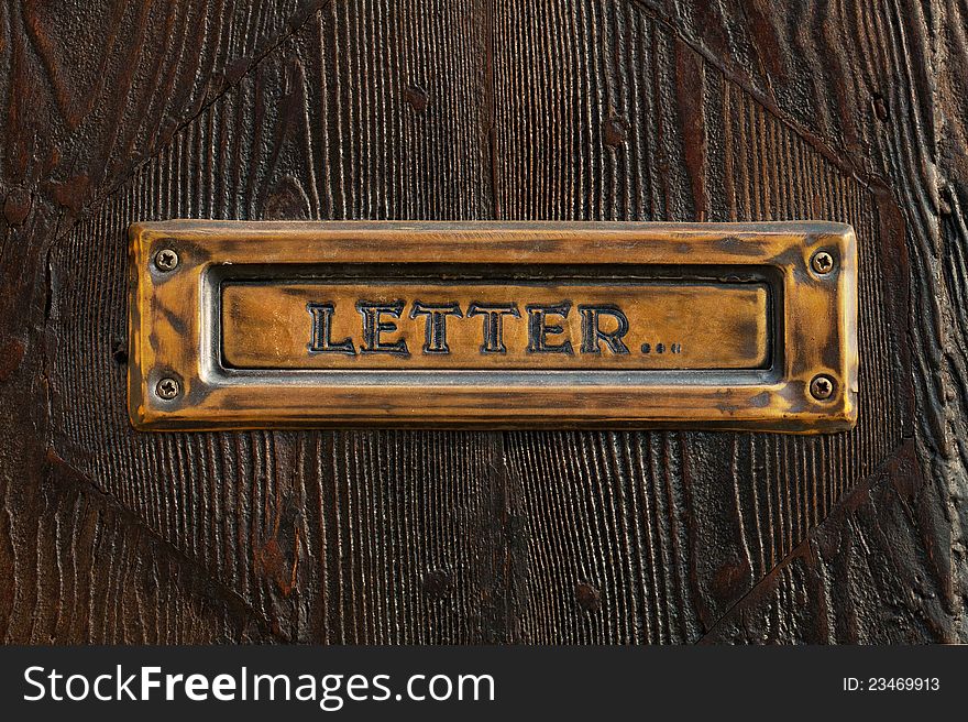 Semi-antique mail box against a door of a dark tree. Semi-antique mail box against a door of a dark tree