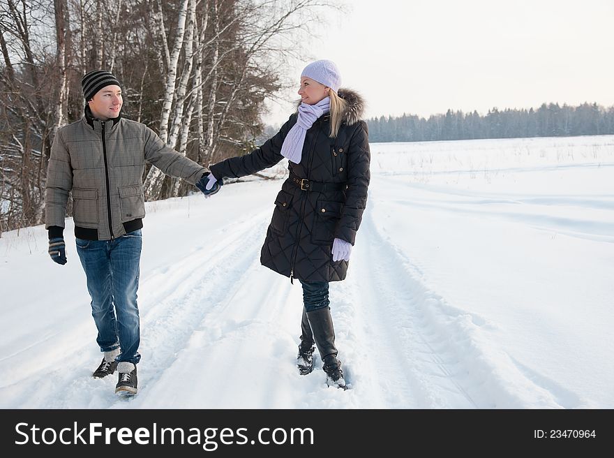 Man and women walk on the winter road. Man and women walk on the winter road