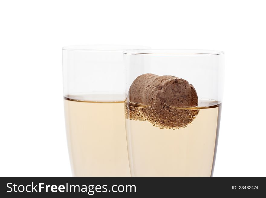 Glasses of champagne with cork isolated on white