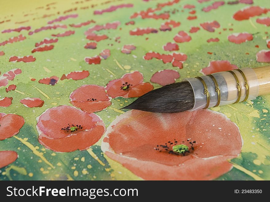 Close up photo of handmade sable brush on watercolor painting of field poppies