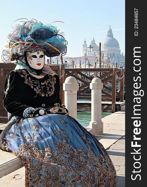 Cyan lady mask with hat at gondola pier . Cathedral in background . 2012 Venice Carnival. Cyan lady mask with hat at gondola pier . Cathedral in background . 2012 Venice Carnival