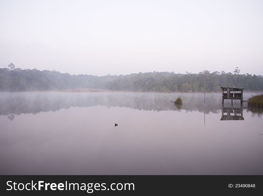 Misty still creek with cottage in the foggy morning. Misty still creek with cottage in the foggy morning.