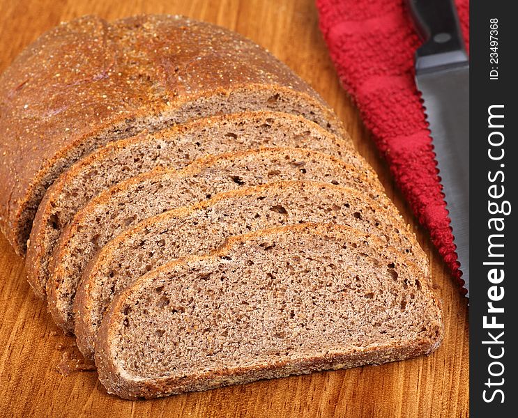 Loaf of rye bread sliced on a cutting board. Loaf of rye bread sliced on a cutting board