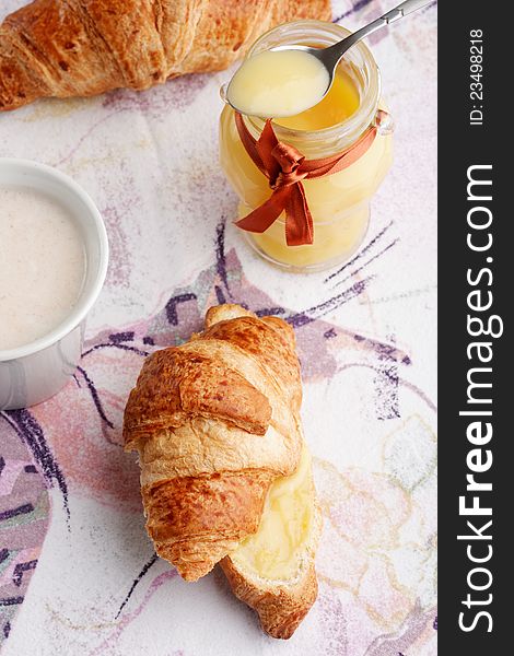Breakfast with milk, lemon curd and croissants