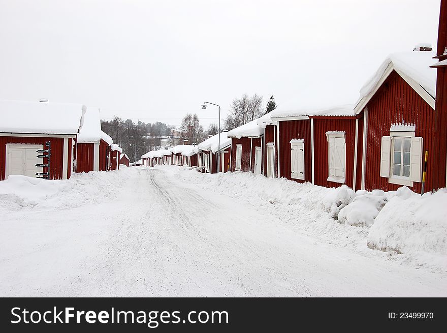 Snowy street in north Sweden with red houses