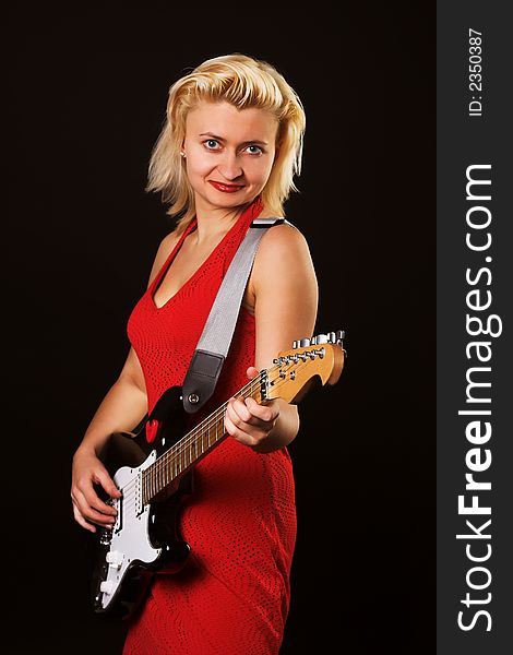 Singer girl with guitar over black background