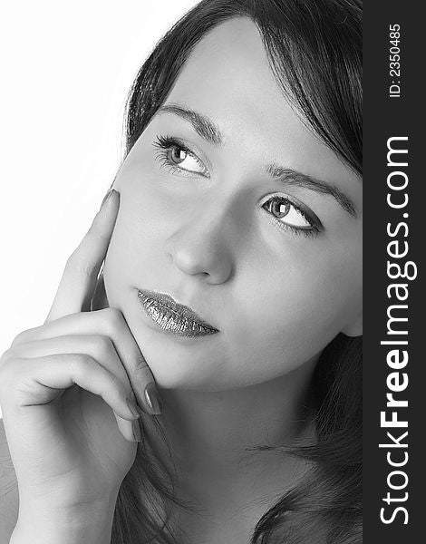 Portrait of the beautiful girl put the face on a hand and holding a finger on a cheek over white background